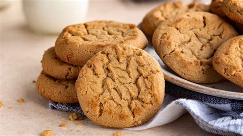 Plato con galletas de mantequilla de maní y nueces, algunas con marcas de tenedor