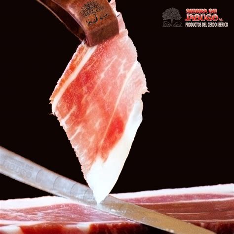 Fotografía detallada de una loncha de jamón ibérico mostrando el veteado y la infiltración de grasa característica.