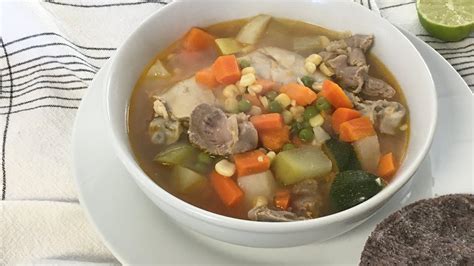Fotografía gastronómica de un plato hondo con sopa de verduras y mollejas de pollo, decorado con huevo rallado