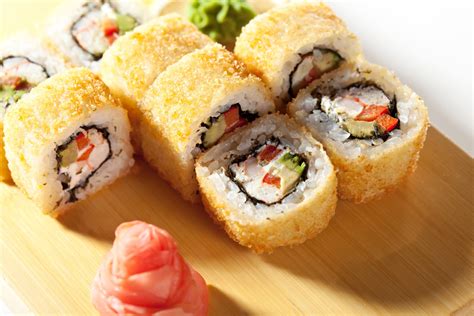 Fotografía profesional de un rollo de sushi de estilo fusión que muestra el relleno de queso crema en su interior.