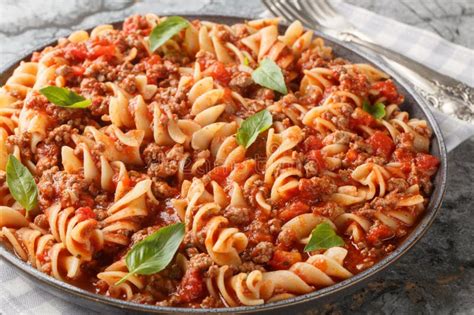 Fotografía de un plato de pasta con carne molida y salsa de tomate espolvoreado con perejil fresco