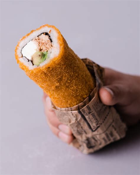 Fotografía detallada de un handroll de salmón fresco con aguacate y semillas de sésamo