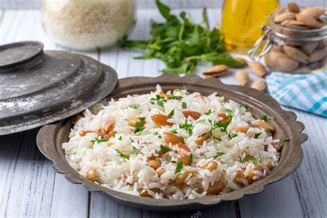 Plato de pilav turco con almendras y pasas, decorado con hierbas frescas.
