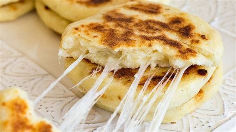 Foto de arepas recién hechas con queso derretido visible, listas para servir.