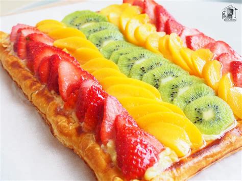 Ilustración de una tarta de hojaldre con crema pastelera y frutas frescas variadas, destacando su colorido y frescura.