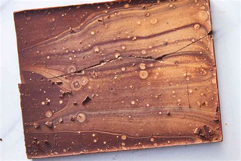 fotografía macro comparativa entre un chocolate con brillo uniforme y uno con fat bloom (manchas blancas)