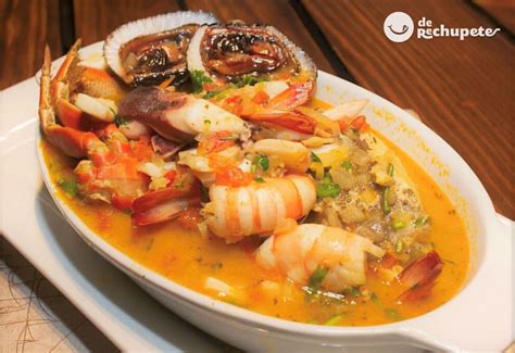 Plato servido de parihuela peruana, con variedad de mariscos y pescado en un caldo rojizo.