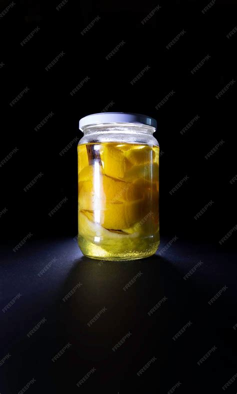 Fotografía de frascos de vidrio con cáscaras de cítricos en proceso de maceración
