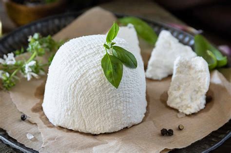 Primer plano de un bol con queso ricotta mezclado con espinacas picadas y condimentos.