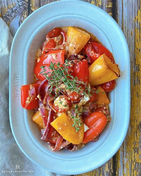 Bandeja de horno con papas, pimientos, cebolla y tomates cherry, lista para ir al horno.