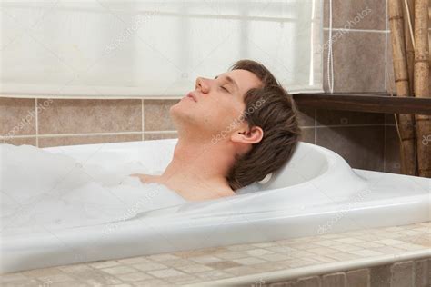 Persona relajándose en una bañera con sales de baño