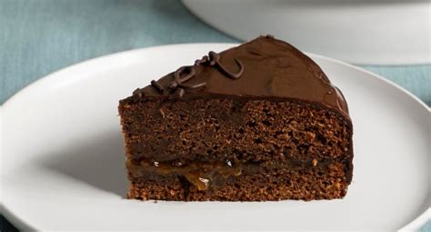 Ilustración de un queque de chocolate entero y una porción cortada mostrando su textura húmeda