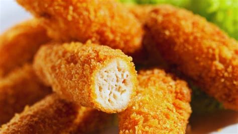 Plato de bastones de pollo apanados horneados con un dip de pimentón al lado