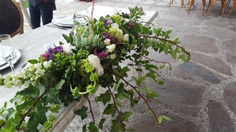 Sillas rústicas decoradas con follaje verde y pequeños detalles florales