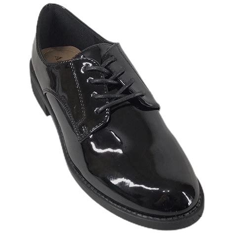 Zapato en miniatura negro con cordones blancos y formador de madera.