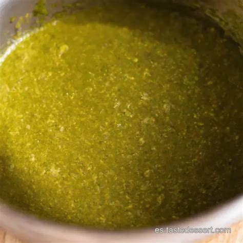 Foto detallada de una salsa verde casera sobre filetes de pescado blanco