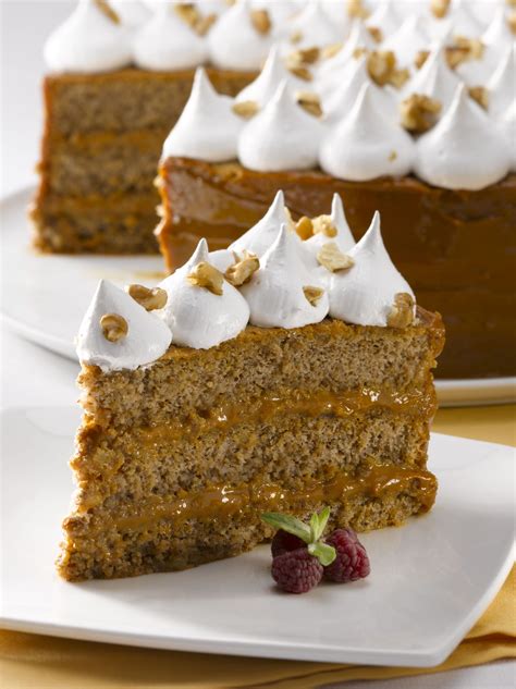 Torta de capas con relleno de manjar y decoración con merengue y nueces, con toques de verde menta