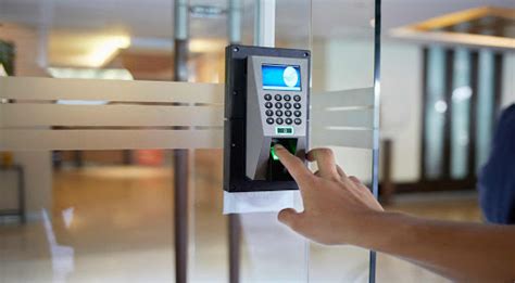 Fotografía de un trabajador registrando su entrada en un reloj control.