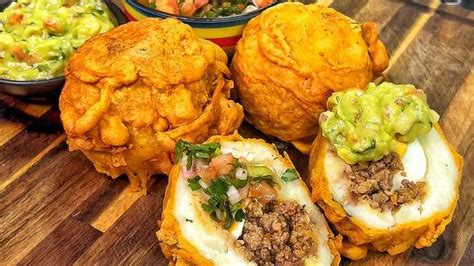 Foto de papas rellenas recién hechas, una frita y otra horneada, mostrando la textura crujiente