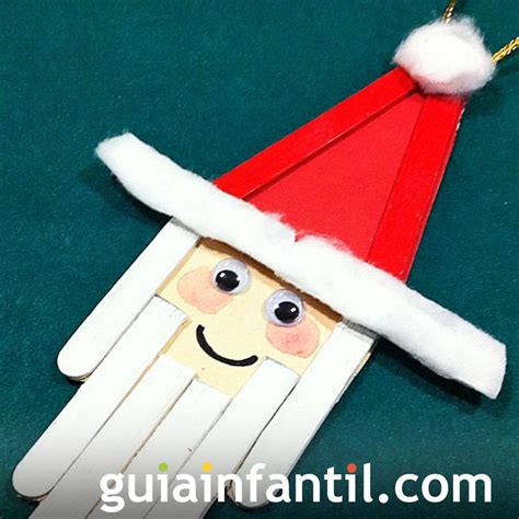 Reno de Papá Noel hecho con palitos de helado, mostrando un cuerpo amarillo, cuernos y un collar con cascabeles.
