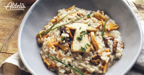 Primer plano de un risotto cremoso con setas y hierbas frescas