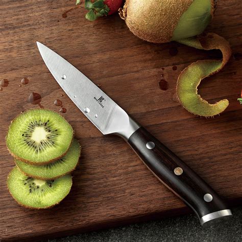 Primer plano de un cuchillo pelador de alta calidad sobre una tabla de cortar con cebollas.