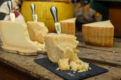 Infografía mostrando la región de producción del Parmigiano Reggiano y sus características: pasta dura, color amarillo paja y textura granulosa.