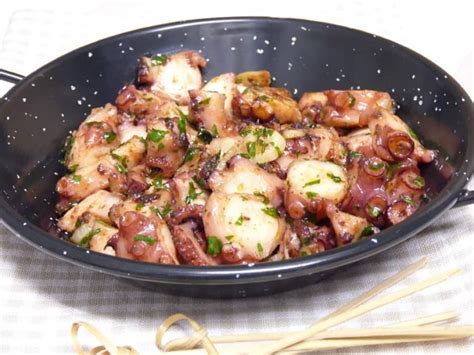 Pulpo al ajillo calentándose en una sartén con ajo y guindilla