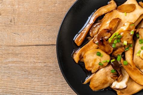 Fotografía profesional de un plato de hongos ostra salteados con mantequilla, espinacas y un toque de salsa de soja, servido con arroz blanco.