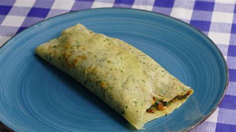 crepes rellenos de pollo y espinacas servidos en un plato