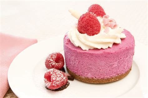 tarta mousse de frambuesa con base de galleta y decorada con frutos rojos y menta