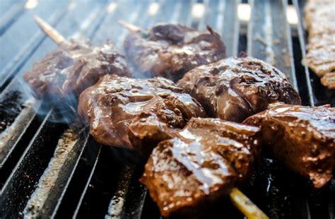 Fotografía apetitosa de anticuchos listos para servir en una parrilla