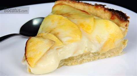 Tarta con la base precocida rellena de crema pastelera y cubierta uniformemente con rodajas de manzana.