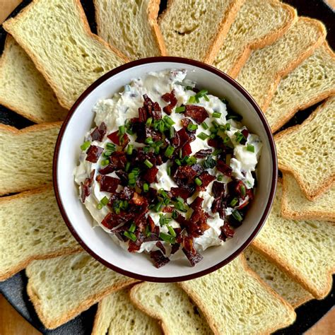 Plato surtido con dip de queso crema, panes variados, crackers y verduras frescas