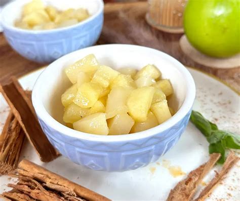 Primer plano de las manzanas cocidas en la olla, mostrando la textura tierna y el glaseado.