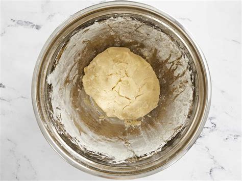 Ingredientes secos y húmedos mezclándose para formar una masa de pan
