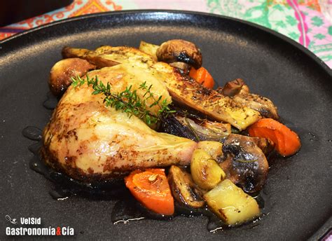 Imagen de una bandeja con pollo dorado y verduras asadas en el horno.