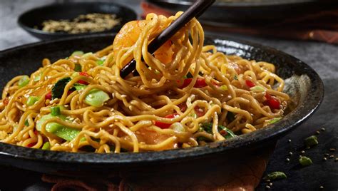 Plato de noodles con pollo y verduras variadas