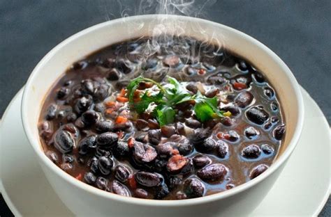 Tazón de guiso de porotos negros humeante con decoraciones