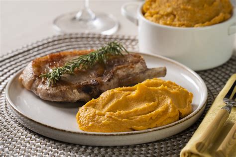 fotografía gastronómica de un plato elegante con puré de camote decorado con hierbas frescas