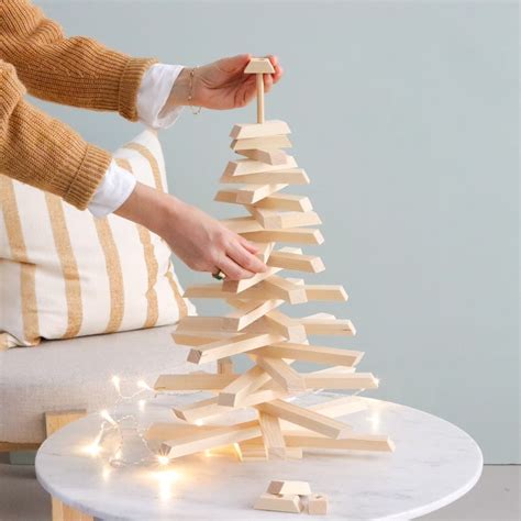 Una mesa festiva decorada con un árbol de Navidad hecho de galletas de diferentes tamaños.