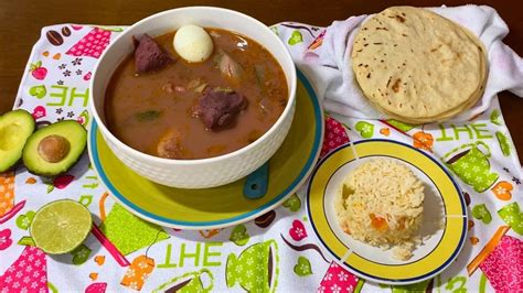 Un plato humeante de sopa de frijoles salvadoreña, con tortillas y queso.