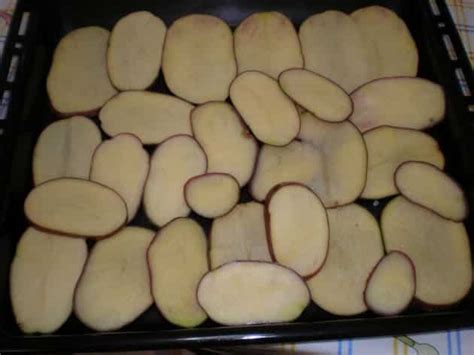 Bandeja de horno con papas laminadas listas para verter la mezcla líquida