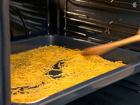 bandeja de horno con fideos esparcidos y dorándose