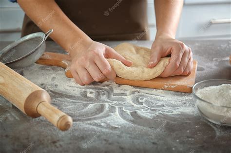 Foto de manos amasando una masa de galleta de jengibre sobre una superficie limpia.