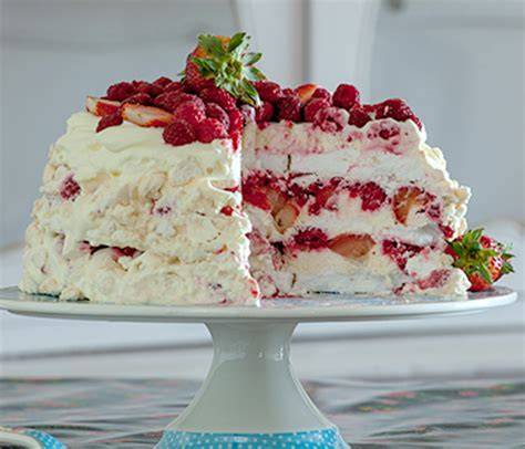 Torta de merengue con frambuesas decorada y glaseado blanco