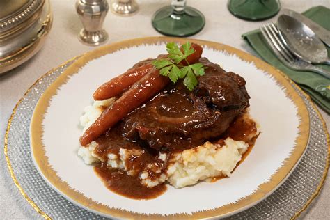 Plato de osobuco estofado servido sobre una base de polenta cremosa con hilos de queso derretido.